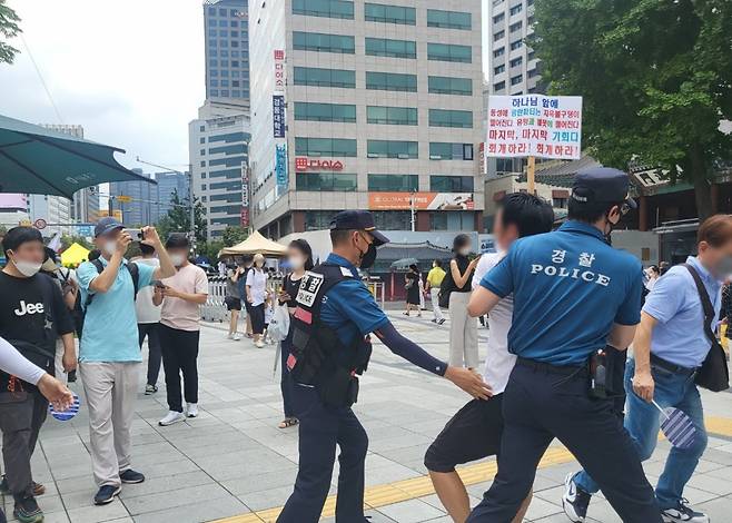 16일 오후 서울 중구 덕수궁 대한문 앞에서 열린 ‘퀴어축제’ 반대 집회에서 한 참가자가 퀴어축제가 열리는 서울광장 쪽으로 이동하려다 경찰관들에게 저지되고 있다. 박혜원 기자