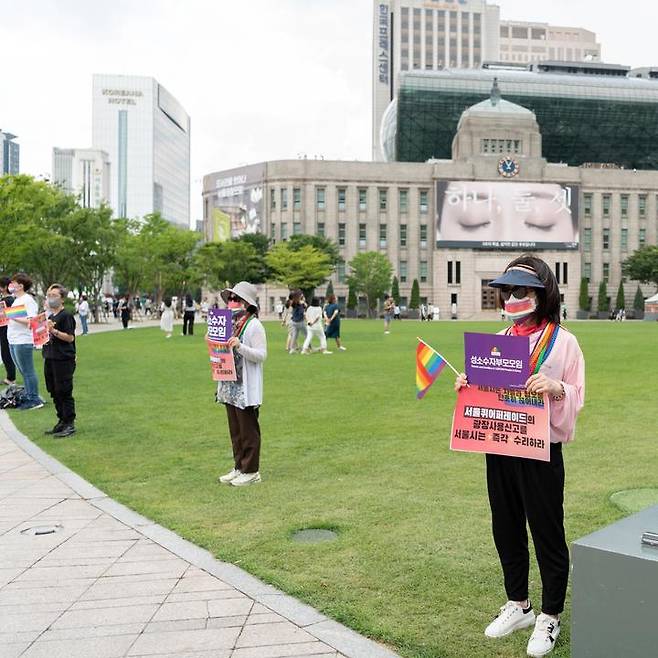 [서울=뉴시스]지난 6월 성소수자부모모임 관계자가 서울시에 서울퀴어퍼레이드의 광장사용 신고를 즉각 수리할 것을 요구하는 피켓을 들고 서 있다. (사진=서울퀴어퍼레이드 홈페이지 캡처) *재판매 및 DB 금지