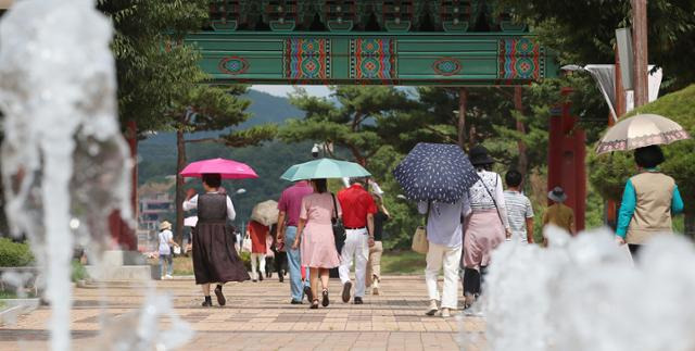 대구와 경북 경산 지역에 폭염경보가 발효된 15일 경산시 남산면 삼성현역사문화공원을 찾은 시민들이 양산을 펼쳐 뙤약볕을 피하고 있다. 뉴스1