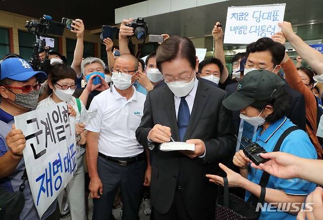 [서울=뉴시스] 김선웅 기자 = 이재명 더불어민주당 의원이 17일 오후 서울 여의도 국회 소통관에서 당대표 출마 선언 기자회견을 마친 후 한 지지자에게 사인을 해주고 있다. (공동취재사진) 2022.07.17. photo@newsis.com