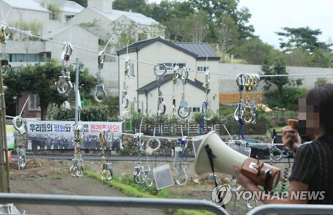 확성기 시위 (양산=연합뉴스) 이정훈 기자 = 문재인 전 대통령에 반대하는 단체 회원들이 17일 낮 문 전 대통령 사저가 있는 경남 양산시 하북면 지산리 평산마을에 모여 문 전 대통령 수사, 전직 대통령 예우박탈 등을 주장하는 집회를 하고 있다. 한 반대단체 회원이 사저 앞에서 확성기를 사용해 문 전 대통령 비판 발언을 하고 있다. 2022.7.17 seaman@yna.co.kr