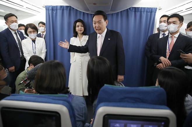 윤석열 대통령이 2022년 6월27일 북대서양조약기구(나토) 정상회의에 참석하기 위해 스페인 마드리드로 향하는 대통령 전용기 안에서 기자들과 이야기를 나누고 있다. 김건희 여사도 취재진에게 인사했다. 연합뉴스