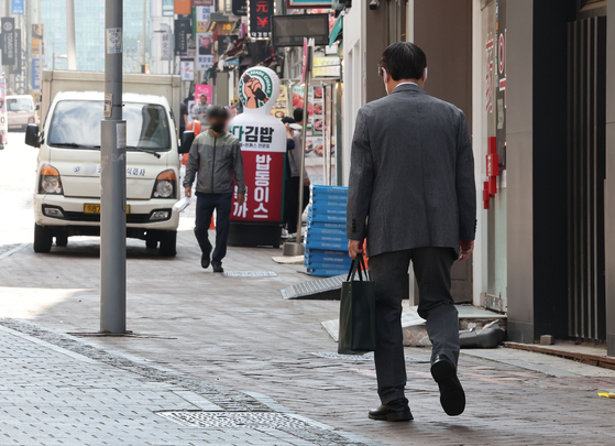 대법원이 연령만을 이유로 부당하게 임금을 삭감하는 임금피크제가 무효라는 판단을 내리면서 노사 간 공방이 뜨겁다. 사진은 서울 시내 거리를 걷는 중년 남성의 모습. 연합뉴스