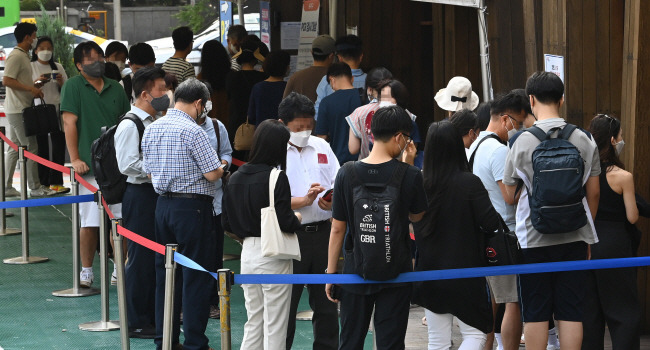 다시 붐비는 선별진료소 : 코로나19 신규 확진자가 83일 만에 최다인 7만3582명을 기록한 19일 오전 서울 송파구보건소 선별진료소에 시민들이 진단검사를 받기 위해 길게 줄지어 서 있다.    김호웅 기자