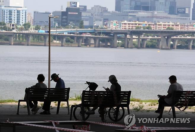 시민들이 그늘에서 뜨거운 태양을 피하고 있다.