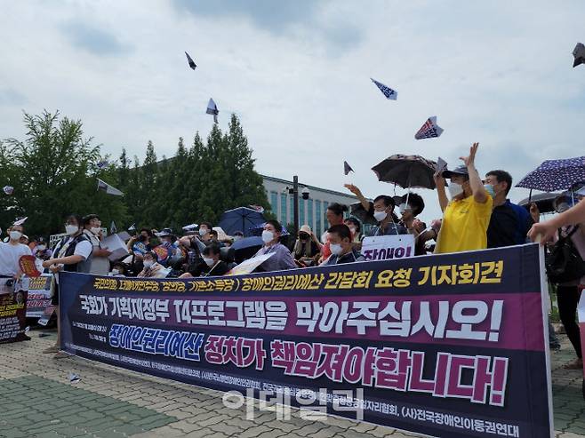 전장연은 20일 오후 서울 영등포구 국회 앞에서 ‘장애인권리 예산 보장, 정치가 책임져라’란 문구를 담은 종이비행기 1만개를 국회로 날려 보내는 퍼포먼스를 진행했다.(사진=황병서 기자)