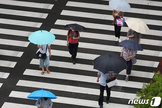 대구 수성구 달구벌대로에서 출근길 시민들이 비를 피하기 위해 우산을 쓴 채 서둘러 횡단보도를 건너고 있다. 2022.7.11/뉴스1 © News1 공정식 기자