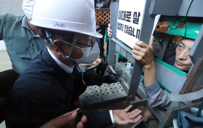 대우조선해양 하청 노동자들이 28일째 대우조선해양 옥포조선소를 점거하고 농성 중인 가운데 19일 오후 경남 거제시 대우조선해양 옥포조선소 파업 현장을 찾은 이정식 고용노동부 장관(왼쪽)이 제1도크 안 선박에 설치된 가로·세로·높이 1m의 철제 구조물 안에서 농성 중인 유최안 민주노총 금속노조 거제·통영·고성 조선하청지회 부지회장과 이야기를 나누고 있다. 공동취재사진