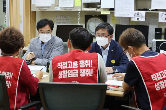 더불어민주당 우원식 의원과 김성환 정책위의장이 13일 오전 서울 서대문구 연세대학교 노천극장 창고에 마련된 공공운수노조 연세대분회 사무실에서 청소·경비 노동자를 만나 면담하고 있다. 연합뉴스