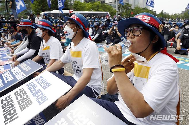 [서울=뉴시스] 고승민 기자 = 전국금속노동조합 회원들이 20일 서울역 앞에서 대우조선하청 투쟁 승리 등을 외치며 행진을 시작해 삼각지역 인근에 도착, 집회를 하고 있다. 여의도로 상경해 단식농성중인 금속노조 거제통영고성조선하청지회 노동자들이 금속노조와 합류해 피켓을 두고 앉아 있다. 2022.07.20. kkssmm99@newsis.com