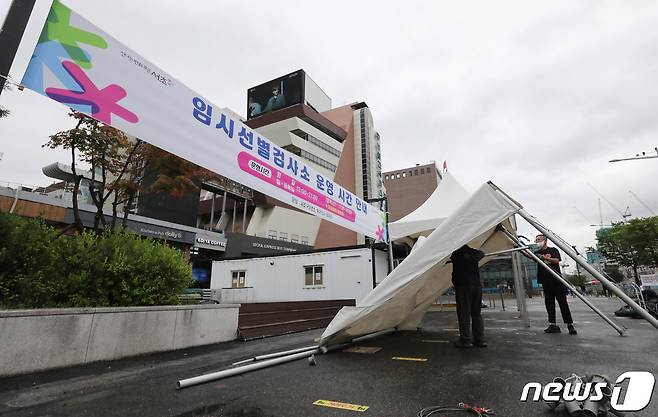 운영 재개를 하루 앞둔 21일 서울 서초구 고속버스터미널 임시선별검사소에서 관계자들이 그늘막 설치 및 운영준비를 하고 있다. 2022.7.21/뉴스1 © News1 박지혜 기자