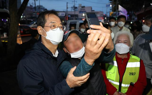 한덕수 국무총리가 5월 27일 서울 구로구 남구로역 인근 새벽인력시장에서 만난 일용직 노동자와 기념촬영을 하고 있다. 뉴스1