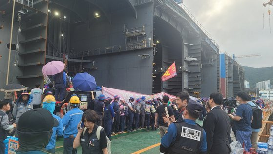 22일 대우조선해양 조선소 1번 독을 점거하고 있던 유최안 하청지회 부지부장이 이송되는 모습을 노조원들이 가리고 있다. 위성욱 기자