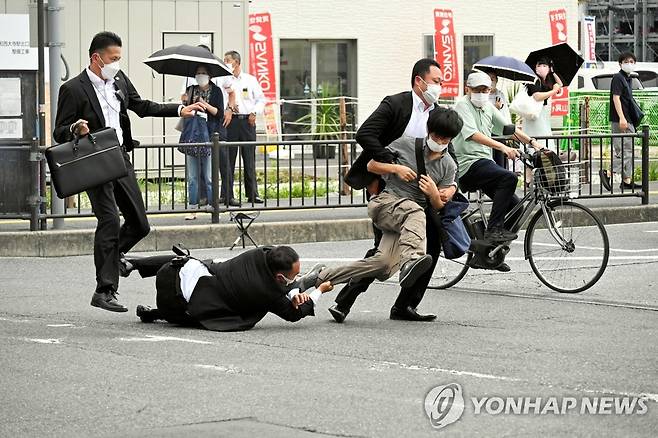 아베 총격범 제압하는 경호팀 (나라 로이터=연합뉴스) 2022년 7월 8일 일본 나라현 나라시에서 아베 신조 전 총리에게 총을 쏜 야마가미 데쓰야가 경호원들에게 제압당하고 있다.