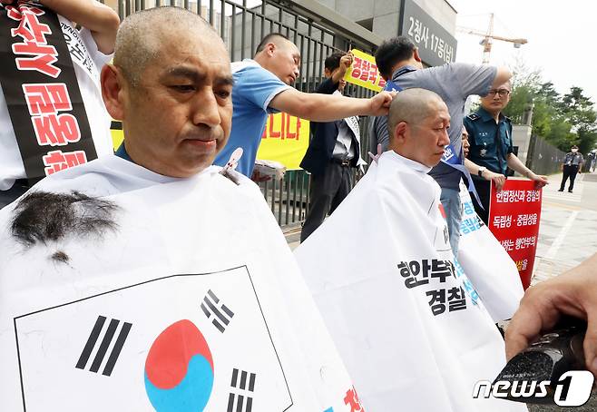 전국경찰직장협의회(직협) 소속 장유석 청주상당경찰서 직협회장과 윤홍선 인천삼산경찰서 직협 회장, 경남청 김건표 경위가 지난 5일 오전 정부세종2청사 행정안전부 앞에서 경찰국 신설 정책 철회를 요구하는 호소문을 발표한 뒤 릴레이 삭발을 하고 있다. 2022.7.5/뉴스1 © News1 김기남 기자