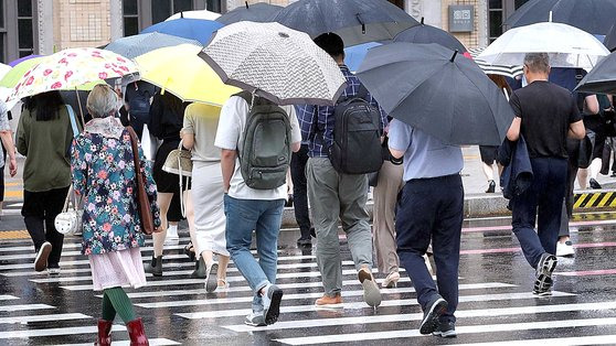 비가 내린 21일 서울 광화문 일대에서 우산 쓴 시민들이 이동하고 있다. 뉴스1