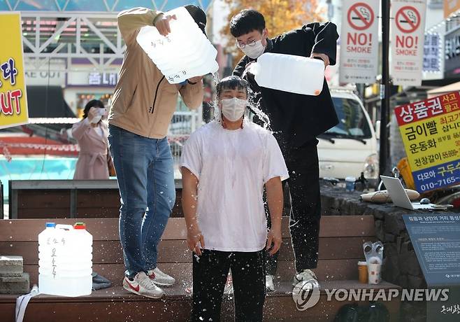 '부패·구태 정치권 각성하라' [연합뉴스 자료사진] 지난해 11월 17일 대구 중구 동성로에서 행동하는 보수지지연대 회원과 지역 청년 등이 기성 정치권의 부패와 구태를 규탄하는 집회를 열고 요소수 파동 등 현 정권의 문제해결 능력에 대한 비판의 의미로 요소수 통에 담긴 물을 몸에 붓는 퍼포먼스를 하는 모습. 2021.11.17