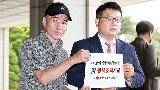 2020년 9월 북한군이 피살한 해양수산부 공무원 고(故) 이대준 씨의 형 이래진 씨가 22일 오전 서울 서초구 중앙지검 앞에서 서훈 전 국가안보실장, 김종호 전 청와대 민정수석, 이광철 전 민정비서관을 공무집행방해 혐의로 고발하기 앞서 기자회견을 하고 있다. 오른쪽은 유가족 측 변호인 김기윤 변호사. 연합뉴스