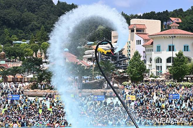 [용인=뉴시스] 김종택기자 = 전국 대부분 지역에 폭염주의보가 내려진 25일 오후 경기도 용인 캐리비안베이를 찾은 시민들이 시원한 물줄기를 뿜으며 하늘을 나는 플라이보드쇼를 보며 더위를 식히고 있다. 2022.07.25. jtk@newsis.com