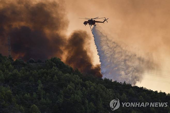 헬기 동원해 산불 진화 (ilialive.gr/AP=연합뉴스) 24일(현지시간) 그리스 아테네 남서부 크레스테나 마을 인근에서 헬기가 산불 진화를 위해 물을 뿌리고 있다. 2022.7.25 [ilialive.gr 제공. 재판매 및 DB 금지]