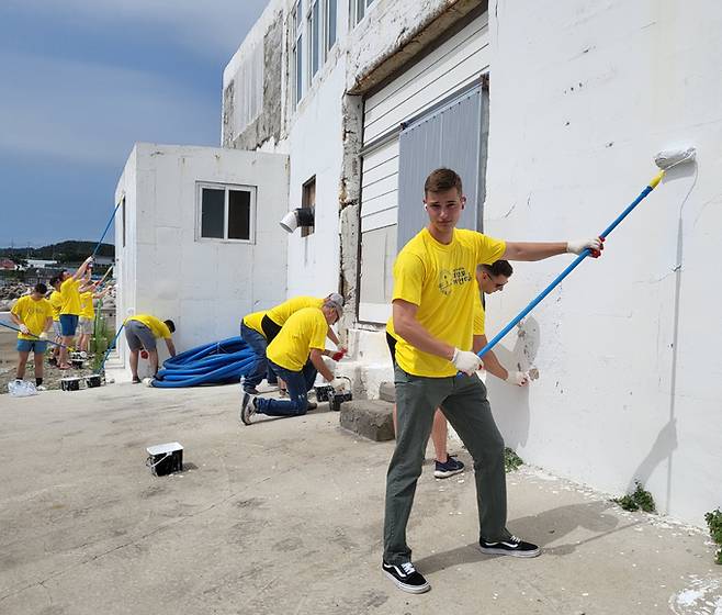 경북 포항에 주둔 중인 미 해병대 캠프무적 장병들이 23일 다무포 하얀마을 해녀랑 고래랑 담벼락 페인팅 축제에 참석해 재능기부를 하고 있다. 다무포 하얀마을 담벼락 페인팅 축제는 그리스 산토리니 처럼 마을 이미지를 바꾸는 프로젝트로 전해졌다. 다무포하얀마을 추진위원회 제공. 포항=뉴스1