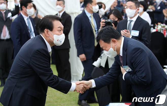 윤석열 대통령이 25일 용산 대통령실 청사 앞 잔디마당에서 열린 2022 대한민국 중소기업인대회에서 신동빈 롯데그룹 회장과 악수를 나누고 있다. (대통령실사진기자단) 2022.5.25/뉴스1 © News1 오대일 기자