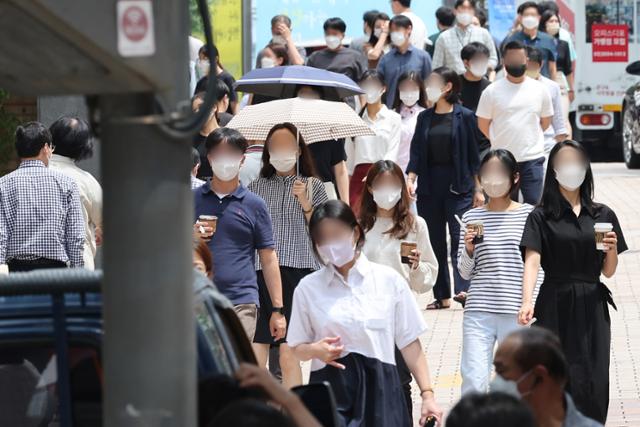 코로나19 신규 확진자가 10만 명을 넘어선 27일 서울 중구 명동에서 마스크를 쓴 시민들이 걸어가고 있다. 이날 정부는 규제에 의한 사회적 거리두기 없이 자율 방역을 독려해 코로나19 재유행의 위기를 극복하기 위한 '일상 방역 생활화 추진방안'을 발표했다. 연합뉴스