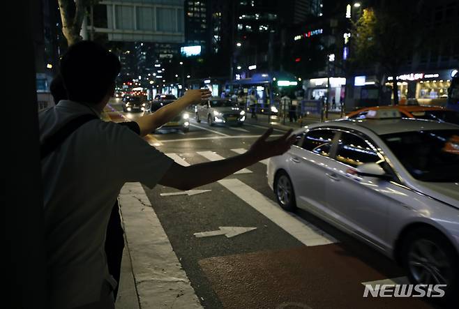 [서울=뉴시스] 고승민 기자 = 원희룡 국토교통부 장관이 심야 택시 공급을 늘리기 위해 요금과 호출료 등을 탄력적으로 올려받을 수 있게 하는 '플랫폼 택시 탄력요금제' 도입 방안을 추진키로 했다. 심야 시간대 택시 요금에 상한선을 정해 올려 운행 대수를 늘린다는 계획인데, 가격만 오르고 효과는 없어 결국 소비자 부담만 커질 수도 있다는 우려의 목소리도 나온다. 사진은 지난 19일 밤 서울 도심에서 시민들이 택시를 잡는 모습. 2022.07.19. kkssmm99@newsis.com