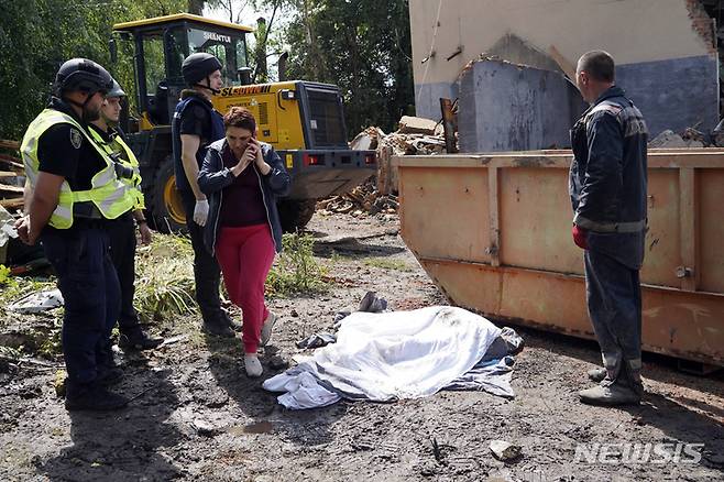 [추흐이우=AP/뉴시스] 지난 22일 우크라이나 하르키우주 추흐이우에서 러시아군의 미사일 공격으로 숨진 여성의 시신 옆에 경찰이 서 있다. 2022.07.27.