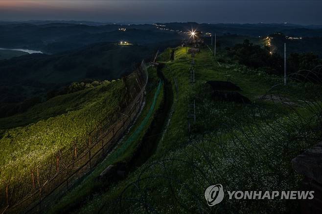 정전협정일 앞둔 비무장지대 (연천=연합뉴스) 임병식 기자 = 6·25전쟁 정전협정 체결(7월 27일) 69주년을 앞둔 비무장지대(DMZ)는 여전히 긴장감을 늦출 수 없는 곳이다. 최전방을 지키는 육군 장병은 폭염 속에서 구슬땀을 흘리며 철통 경계 작전을 펼치고 있다. 사진은 지난 25일 밤 경기도 연천군 중서부전선 DMZ에서 남방한계선 철책을 따라 경계등이 켜진 모습. 이곳은 한국전쟁 정전협정 체결 직전까지 고지 사수를 위해 치열한 전투를 벌인 격전지다. 2022.7.26 andphotodo@yna.co.kr