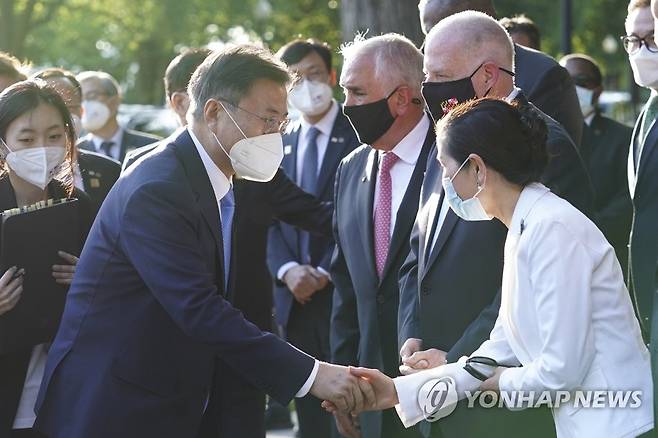 지난해 5월 21일(현지시간) 한미 정상회담을 마친 문재인 전 대통령이 워싱턴 한국전 참전기념비 공원에서 열린 한국전 전사자 추모의 벽 착공식에서 참석자들과 인사하는 모습 [연합뉴스 자료사진]