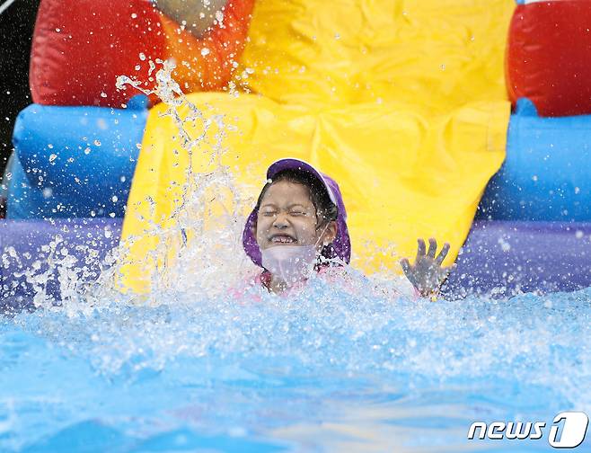 전국 대부분 지역에 특염 특보가 내려진 27일 오후 서울 동작구 동작주차공원에 마련된 물놀이장에서 어린이들이 물놀이를 하며 더위를 식히고 있다. 기상청은 당분간 낮에는 체감온도 33도 안팎의 찜통더위가, 밤에는 최저 기온이 25도를 넘는 열대야가 이어질 것으로 예보했다. 2022.7.27/뉴스1 ⓒ News1 신웅수 기자