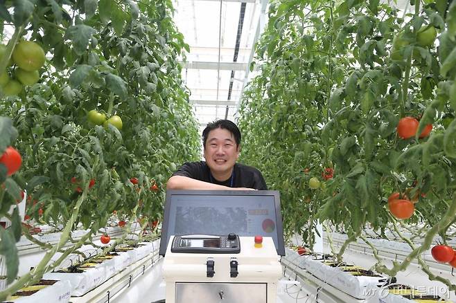 국립농업과학원 농업공학부 스마트팜개발과 김경철 농업연구사가 직접 개발한 '토마토 생산량 모니터링 로봇' 앞에서 환하게 웃고 있다. /사진=정혁수