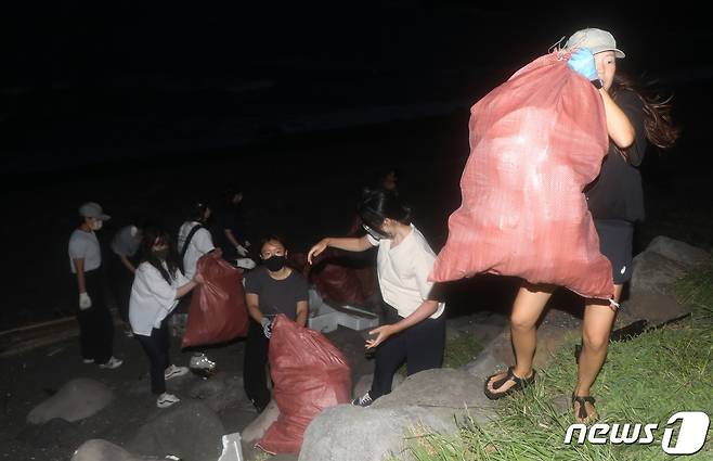 29일 오후 7시 제주 서귀포시 안덕면 사계리 최남단해안로 해변에서 2022 제주플러스 국제환경포럼과 제주 해양쓰레기 수거 청년 단체인 디프다 제주가 함께하는 '다함께 봉그깅' 캠페인 참가자들이 쓰레기를 줍고 있다. '봉그깅'은 줍기라는 뜻의 제주어 '봉그기'와 조깅하며 쓰레기를 줍는 활동을 일컫는 '플로깅(Plogging)'을 합친 단어다.2022.7.30/뉴스1 ⓒ News1 오미란 기자