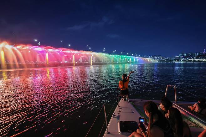 29일 오후 레인보우브릿지 요트페스티벌에 참가한 시민들이 서울 반포한강공원 세빛섬에서 출발한 요트를 타고 반포대교 달빛무지개분수를 배경으로 기념 사진을 찍고 있다. 우상조 기자