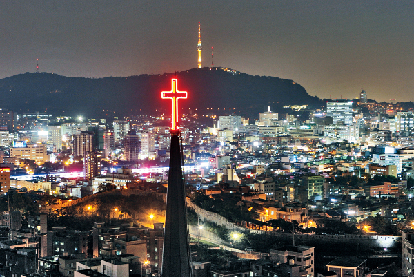 어둠이 짙게 깔린 서울 도심을 배경으로 교회 탑 십자가 불빛이 선명하게 빛나고 있다. 세상 곳곳에서 지쳐 쓰러져 가는 이들이 이 십자가를 보며 다시 희망을 품을 수 있길 기도해본다. 국민일보DB