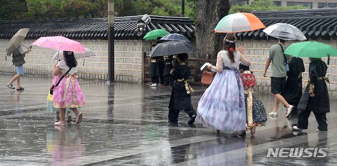 [전주=뉴시스] 김얼 기자 = 시원한 여름비가 내린 지난 13일 전북 전주시 전주한옥마을에서 시민들이 비를 피하며 길을 지나고 있다. 2022.07.13. pmkeul@newsis.com