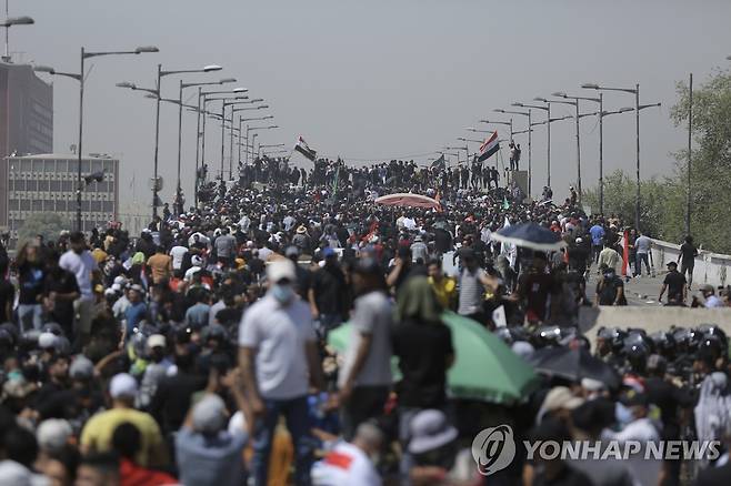 바그다드 그린존으로 향하는 도로를 장악한 반외세 성향 정당 지지자들. (바그다드 AP=연합뉴스) 이라크 시아파 성직자 겸 정치인 무크타다 알사드르 추종자 수백 명이 30일(현지시간) 수도 바그다드의 그린존으로 향하는 다리를 장악한 모습. 2022.7.30. photo@yna.co.kr