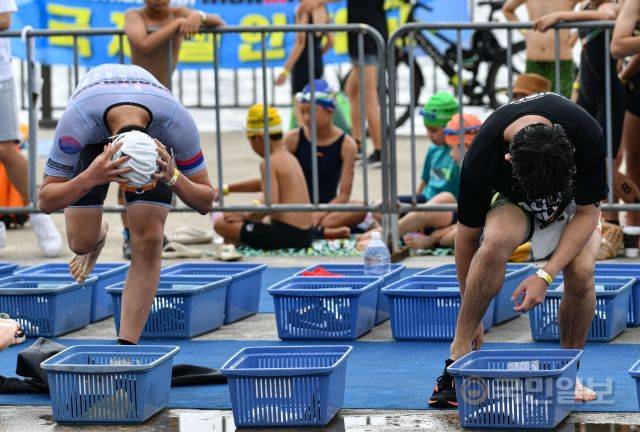 31일 서울 송파구 잠실 한강공원 수중보 일대에서 열린 제18회 서울특별시 철인3종협회장기 아쿠아슬론대회에서 수영을 마친 참가자들이 장비를 착용하고 있다.