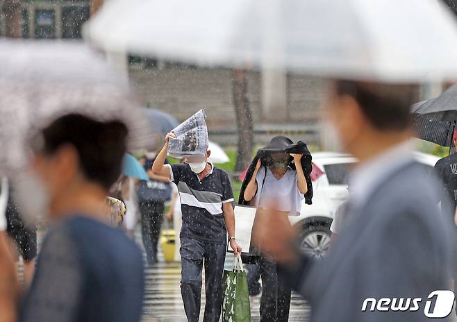 제5호 태풍 '송다'가 북상 중인 31일 서울역 앞에서 시민들이 미처 우산을 준비하지 못하자 신문, 옷 등을 머리 위에 든 채 발걸음을 재촉하고 있다. 2022.7.31/뉴스1 ⓒ News1 조태형 기자