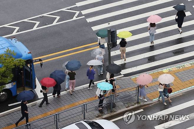 횡단보도 위 알록달록 우산 (서울=연합뉴스) 서대연 기자 = 비가 내린 31일 서울 송파구 잠실역 인근 교차로에서 우산을 쓴 시민들이 횡단보도를 건너고 있다. 2022.7.31 dwise@yna.co.kr