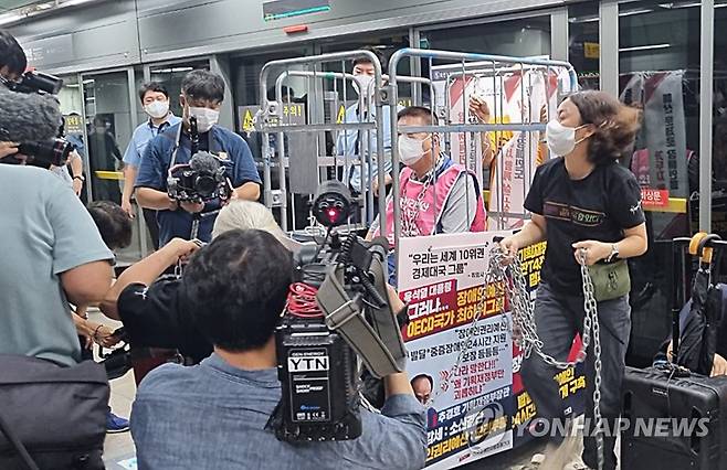 전장연, 한달 만에 '출근길 지하철시위' (서울=연합뉴스) 이정현 기자 = 전국장애인차별철폐연대 관계자가 1일 서울 종로구 지하철 5호선 광화문역에서 장애인 이동권 및 예산 확보를 위한 시위에서 자신의 몸을 이동식 철제 칸막이에 쇠사슬로 묶고 참석해 있다. 2022.8.1 photo@yna.co.kr