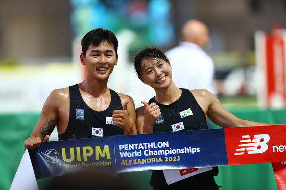 Jun Woong-tae, left, and Kim Sun-woo celebrate after winning the mixed relay event at the UIPM 2022 Pentathlon World Championships in Alexandria, Egypt on Sunday. [XINHUA/YONHAP]