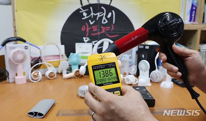 [서울=뉴시스] 김진아 기자 = 2일 서울 종로구 환경보건시민센터에서 최예용 소장이 손선풍기와 목선풍기의 전자파 발생 정도를 비교하기 위해 헤어드라이어의 전자파를 측정하고 있다. (공동취재사진) 2022.08.02. photo@newsis.com