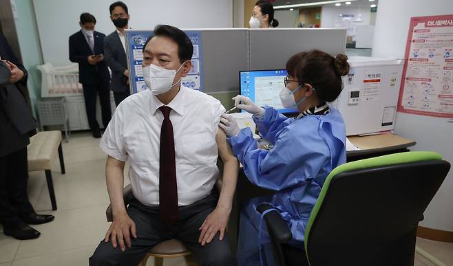 President Yoon Suk-yeol receives his second booster vaccination on July 13 at a public health clinic in Jung-gu, central Seoul. (Yonhap)