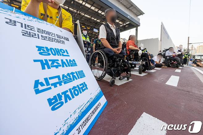 4일 오후 경기도청 주차장 출구에서 장애인 권리 보장을 위한 예산 마련 촉구 집회를 갖고 있는 경기장애인차별철폐연대 회원들. ⓒ 뉴스1