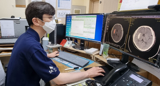 SK(주) C&C 직원이 울릉군보건의료원에서 AI 뇌출혈 영상 의료 솔루션을 설치한 후 테스트하고 있다.    SK(주) C&C 제공