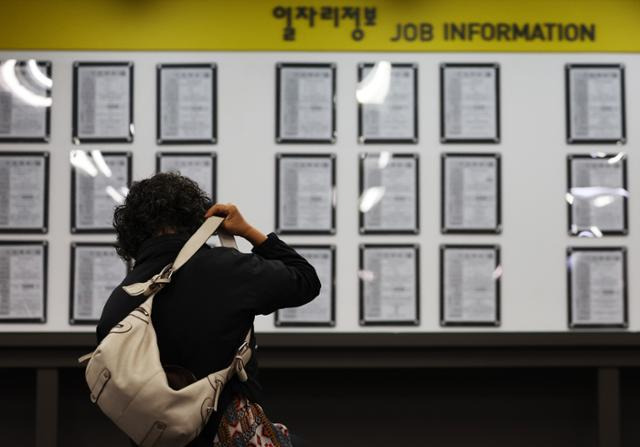 지난달 13일 마포구 서울서부고용복지플러스센터를 찾은 시민이 구인 게시판 앞에 앉아 있다. 연합뉴스