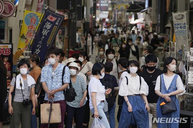 [도쿄=AP/뉴시스] 28일 일본 도쿄에서 코로나19 예방을 위해 마스크를 쓴 시민들이 횡단보도를 건너기 위해 기다리고 있다. 2022.07.29
