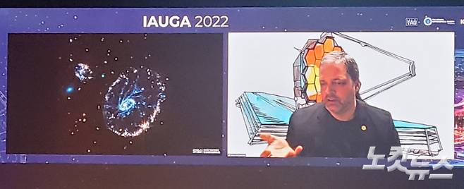우주망원경과학연구소(STScI)의 클라우스 폰토비단 박사가 지난 3일 부산 벡스코에서 진행된 천문우주연맹(IAU) 총회 초청강연에서 제임스 웹이 촬영한 수레바퀴 은하의 이미지를 공개하는 모습. 최원철 기자